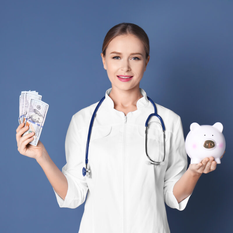 young,female,doctor,holding,money,and,piggy,bank,on,color
